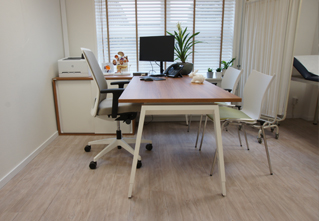 Kantoorinrichting voor medische praktijk met ergonomische bureaustoel en hoogte instelbaar bureau