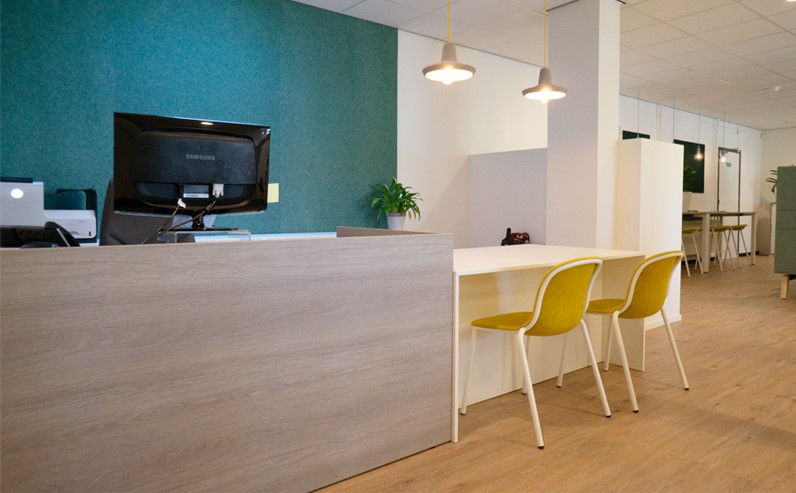 Receptieruimte inrichting met een houten receptiebalie en design stoelen Receptieruimte inrichting met een houten receptiebalie en design stoelen